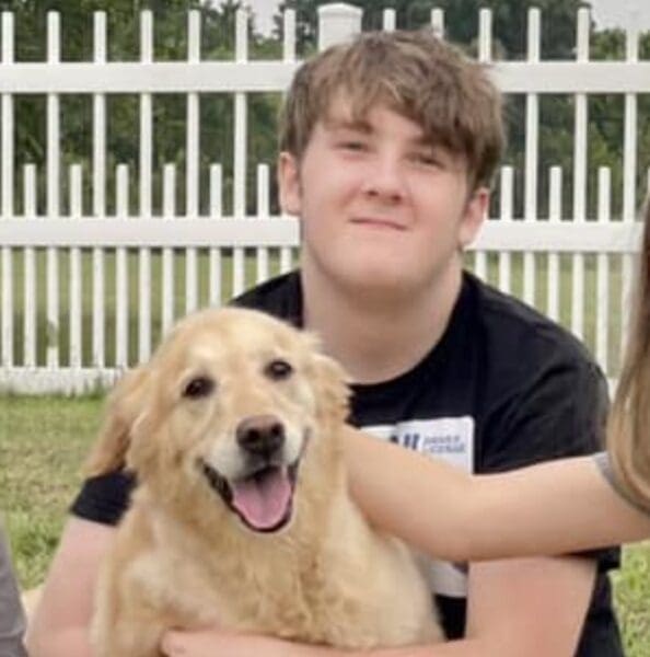 A boy and his dog are smiling for the camera.