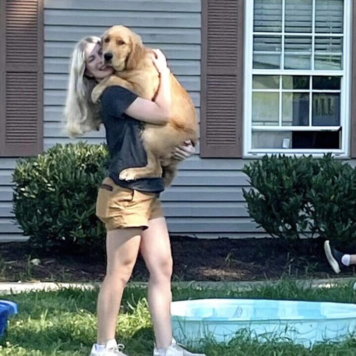 A woman holding a dog in her arms.